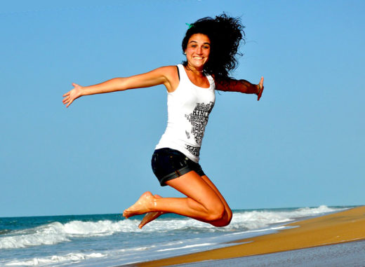 una ragazza salta sulla spiaggia